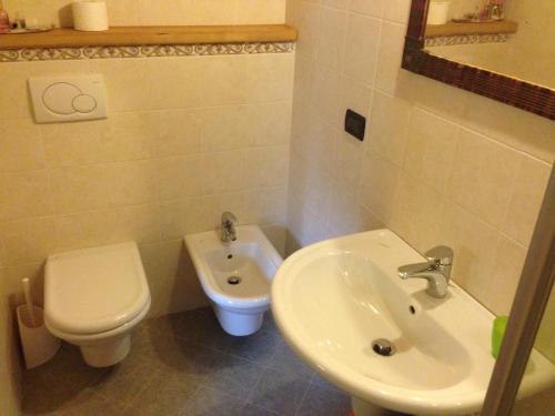 a bathroom with a white toilet and a sink at Il Ciliegio in Imer