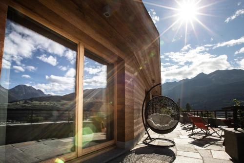 a balcony with a view of the mountains and the sun at Chalet Heidi in Bormio