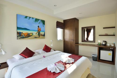 una camera da letto con un grande letto con cuscini rossi e bianchi di At Kamala Hotel a Kamala Beach
