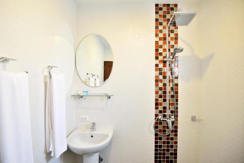 a white bathroom with a sink and a mirror at At Kamala Hotel in Kamala Beach