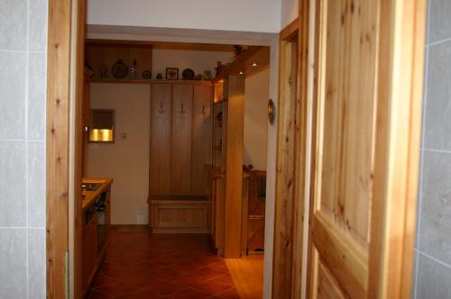 Fewo Nr. 15 Haus Konradgut في سانكت جورجين أوب موراو: ممر يؤدي إلى مطبخ مع خزائن خشبية