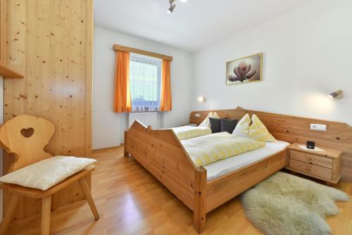a bedroom with a wooden bed and a chair at Fuchshof in Perca