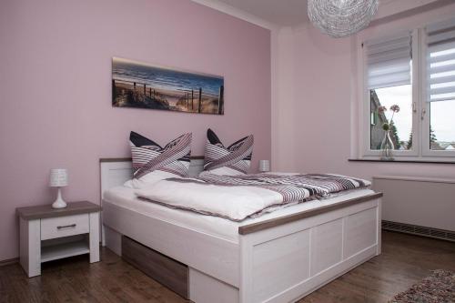 ein Schlafzimmer mit einem weißen Bett mit einem Fenster in der Unterkunft Ferienwohnung am Freizeitpark Bärenloch in Solingen