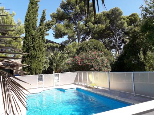 a swimming pool in a yard with trees at Domaine de la Pinsonnière in La Livinière