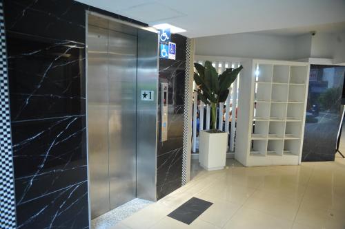 an elevator in a lobby with black marble walls at Great Family Hotel in Taipei