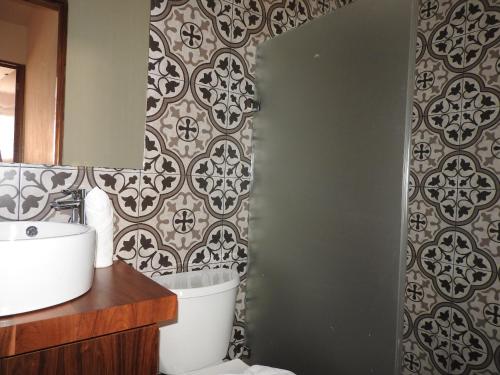 a bathroom with a toilet and a wall at Villas La Ceiba in Playa del Carmen