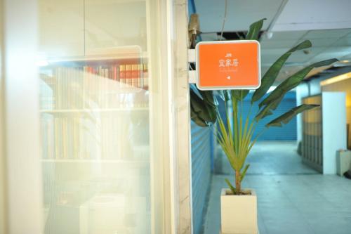 a plant in an office with a sign on a door at Great Family Hotel in Taipei