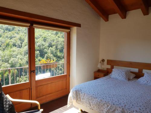 a bedroom with a bed and a large window at Ca La Martra in Toses