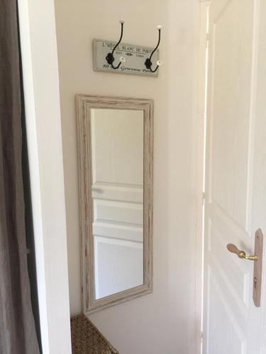 a mirror hanging on a wall next to a door at La Bossellerie in Courdemanche