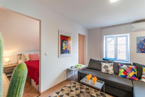 - un salon avec un canapé et un lit dans l'établissement TOP Apartman, à Zagreb