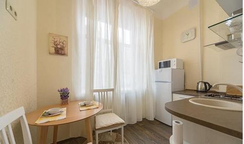 uma pequena cozinha com uma pequena mesa e uma cozinha em Smile Khreschatyk Kyiv em Kiev
