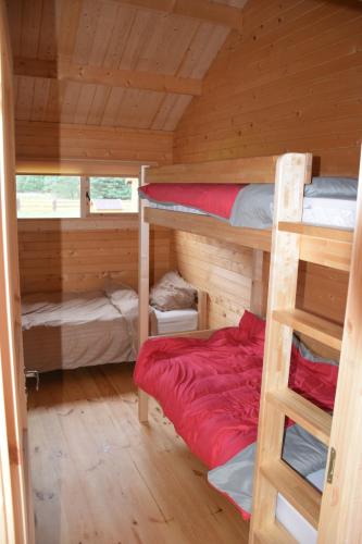 a room with two bunk beds in a cabin at Holandiesi Holiday House in Ķesterciems