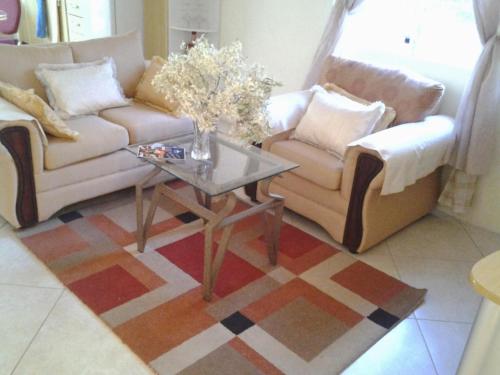 a living room with two couches and a coffee table at Sungold House Barbados in Saint Peter
