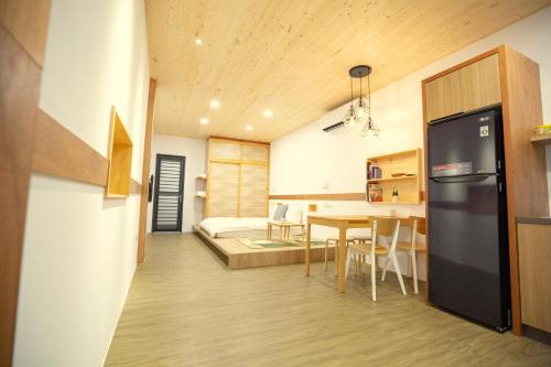 a kitchen and dining room with a refrigerator and a table at Lost Circle Homestay in Tainan