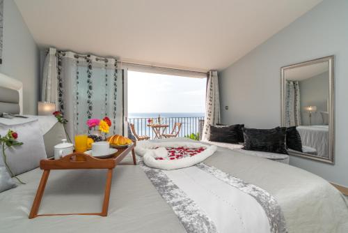 a bedroom with a large bed with a view of the ocean at Zeza´s house in Calheta