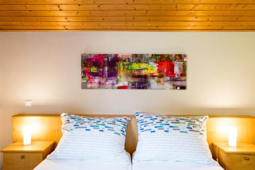 a bedroom with two pillows and a painting on the wall at Gailtal Panorama in Kötschach