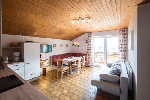 a kitchen and a living room with a couch and a table at Gailtal Panorama in Kötschach