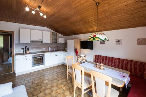 a kitchen and dining room with a table and chairs at Gailtal Panorama in Kötschach