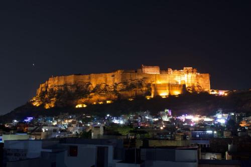 a castle on top of a city at night at Dylan Cafe And Guest House in Jodhpur