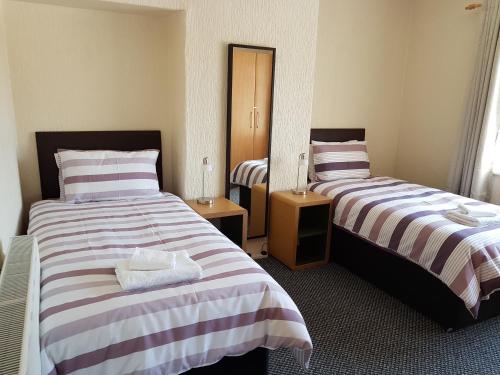 a hotel room with two beds and a mirror at Central Location Preston 2 in Preston