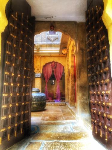 an entrance to a room with red curtains at Desert Haveli Guest House in Jaisalmer