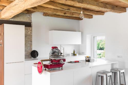 a white kitchen with a red machine on the counter at Relais Poggio Pagnan in Farra