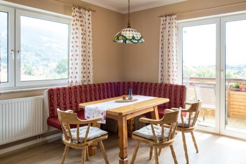 a dining room with a table and a red couch at Gailtal Panorama in Kötschach