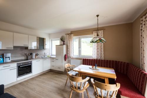 a kitchen and living room with a table and a couch at Gailtal Panorama in Kötschach