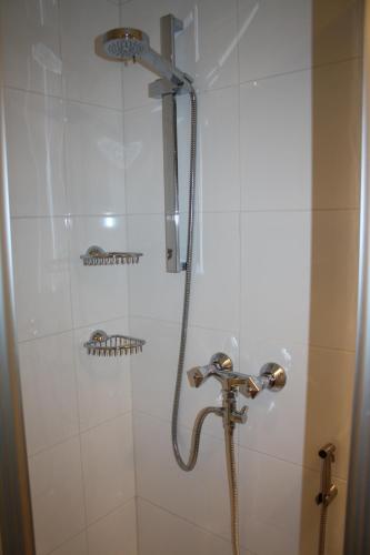 a shower with a shower head in a bathroom at Urlaub am Krausberghof, Apartment mit Balkon und Parkplatz, Aufenthaltsraum, Sauna und Infrarotkabine, inmitten der Natur, kostenfreie Kaffeekapseln, 6 Fahrminuten zur Alpentherme Gastein und zur Schlossalmbahn, Spielplatz, großer Gartenbereich in Bad Hofgastein