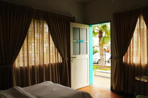 um quarto com uma cama e uma porta de vidro deslizante em La Casa de Algodon em Huacho