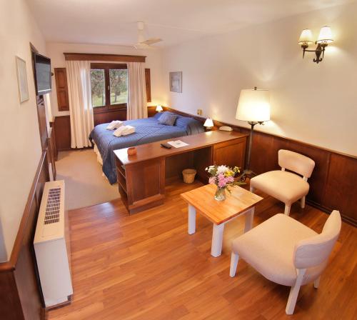 1 dormitorio con cama, escritorio y mesa en Bremen Hotel & Spa en Villa General Belgrano