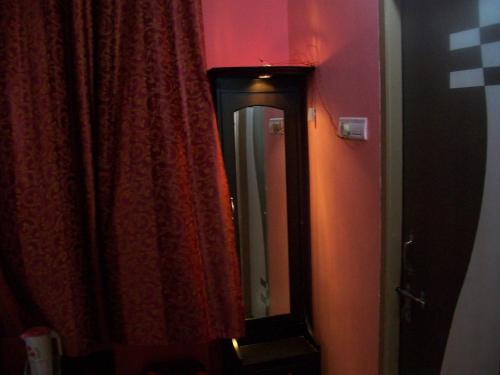 a mirror in a bathroom with a red curtain at Hotel Viraat Inn in Gaya