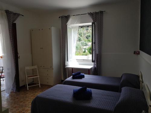 a bedroom with two beds and a window at Casa Sabrina in Lipari