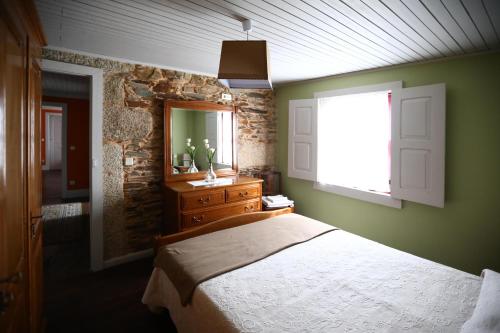 a bedroom with a bed and a mirror and a window at Casa do Lonho in Arouca