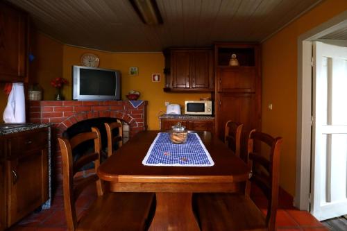 a kitchen with a wooden table and a fireplace at Casa do Lonho in Arouca