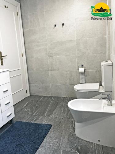 a bathroom with a white toilet and a sink at Palmeras del Golf - Torrequebrada in Benalmádena