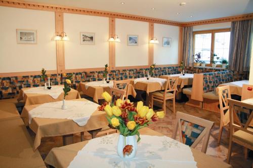 a restaurant with tables with yellow flowers in a vase at Haus Bergkristall in Obergurgl