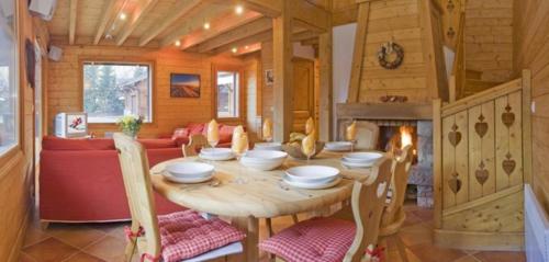 a wooden dining room with a table and a fireplace at Chalet Bois - Chamonix in Chamonix