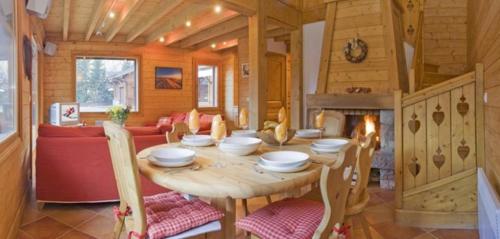 une salle à manger en bois avec une table et une cheminée dans l'établissement Chalet Bois - Chamonix, à Chamonix-Mont-Blanc