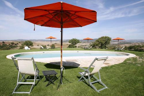 two chairs and a red umbrella next to a pool at Bio Agriturismo La Bell'Antiglia in Montemerano