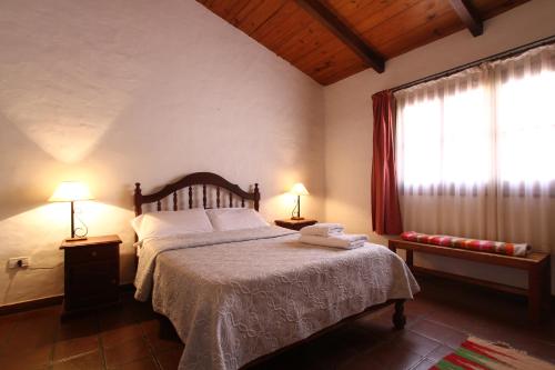 a bedroom with a bed with two lamps and a window at Posta del Sol in Maimará