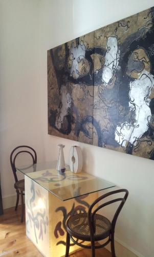 a table with two chairs and a painting on the wall at Whatever Art B&B in Lisbon