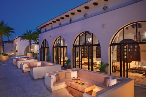 an outdoor patio with couches and tables in a building at Secrets Puerto Los Cabos Golf & Spa18+ in San José del Cabo