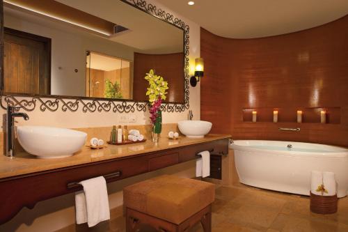 a bathroom with two sinks and a tub and a large mirror at Secrets Puerto Los Cabos Golf & Spa18+ in San José del Cabo