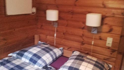 a bedroom with two pillows and a wooden wall at Ferienhaus Nr. 52 im Ferienpark am Twistesee in Bad Arolsen