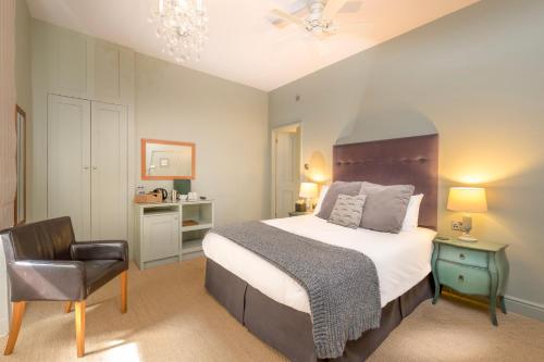 a bedroom with a large bed and a chair at Edgar Townhouse in Bath