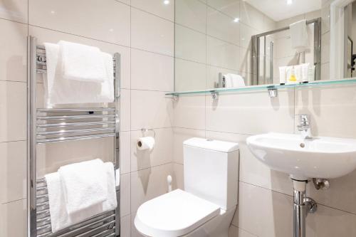 a white bathroom with a toilet and a sink at Edgar Townhouse in Bath