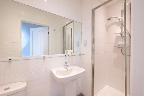 a white bathroom with a sink and a mirror at Edgar Townhouse in Bath