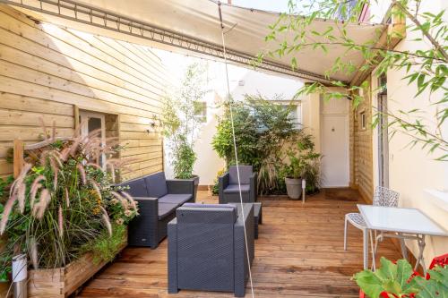 an outdoor patio with chairs and tables and plants at Citotel Le Regina Bordeaux Gare Saint-Jean in Bordeaux