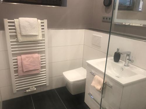 Baño blanco con lavabo y aseo en Apartmentvermietung Meerbusch, en Meerbusch